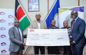 The Chairperson of the Teachers Service Commission (TSC), Dr. Jamleck Muturi, receives a cheque of Ksh 10 million from representatives of Equity Bank. (Photo: TSC)